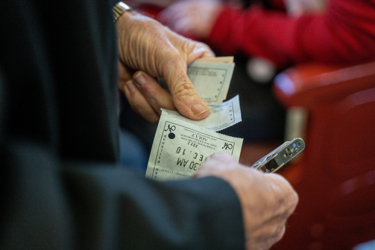 Person holding and checking printed event tickets before entering a venue