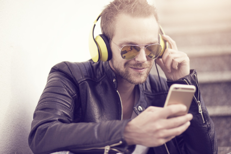 Man watching wrestling matches online on a smartphone with headphones while streaming wrestling videos on mobile