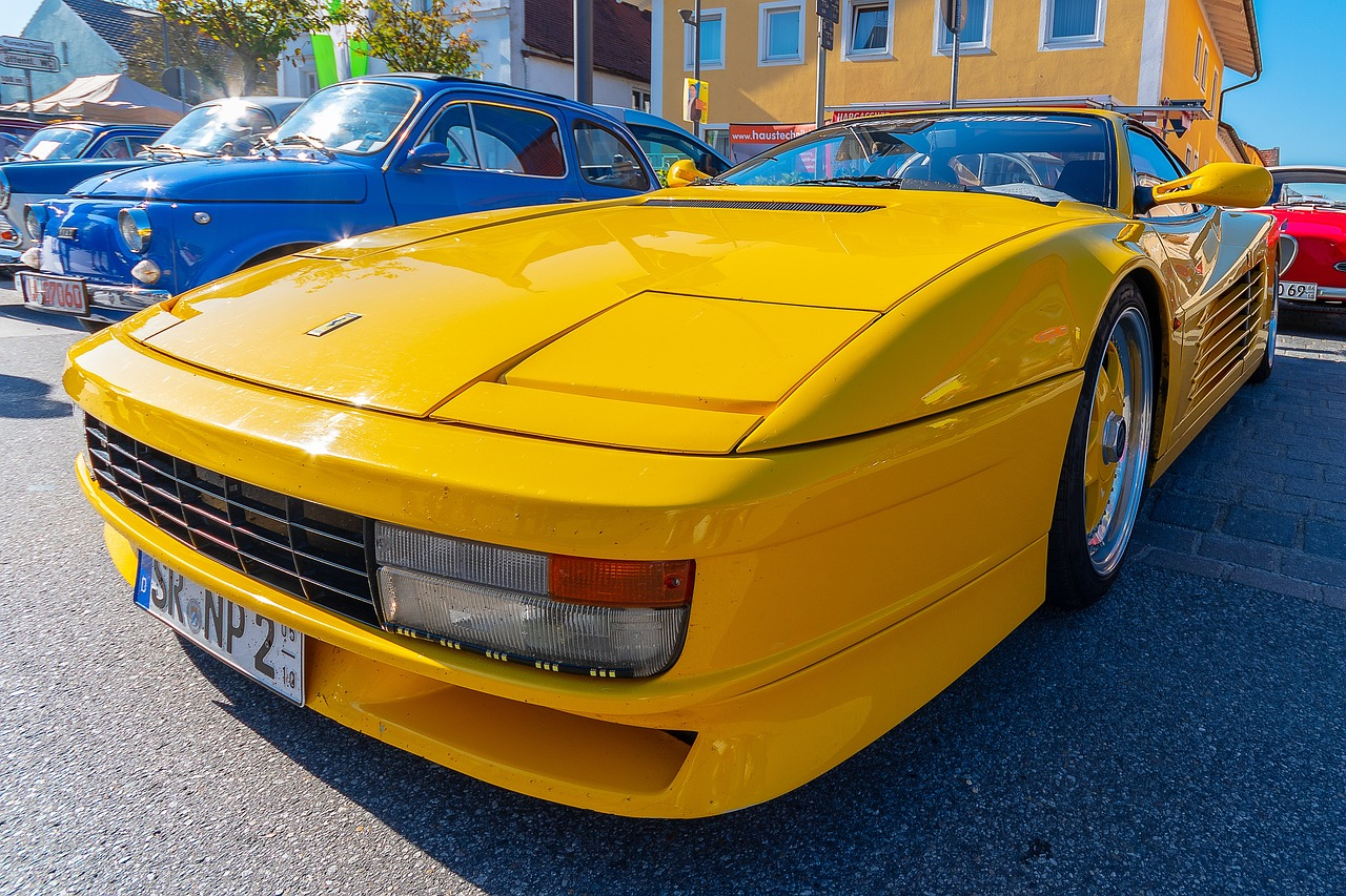 Yellow Ferrari Testarossa parked on a city street during a roadtrip to a live wrestling event